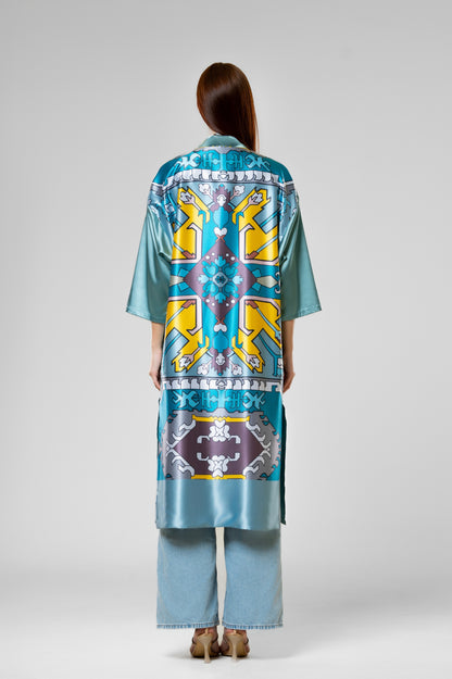 Person wearing a colorful patterned silk robe with signature design.