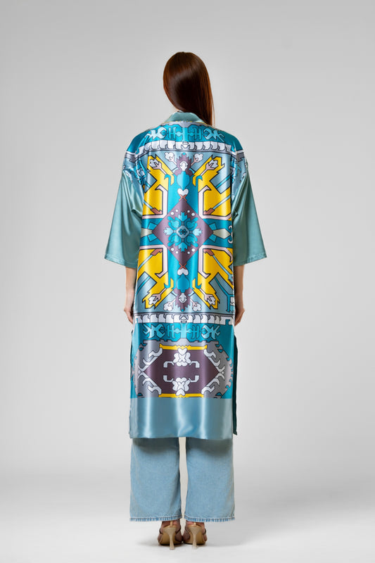 Person wearing a colorful patterned silk robe with signature design.